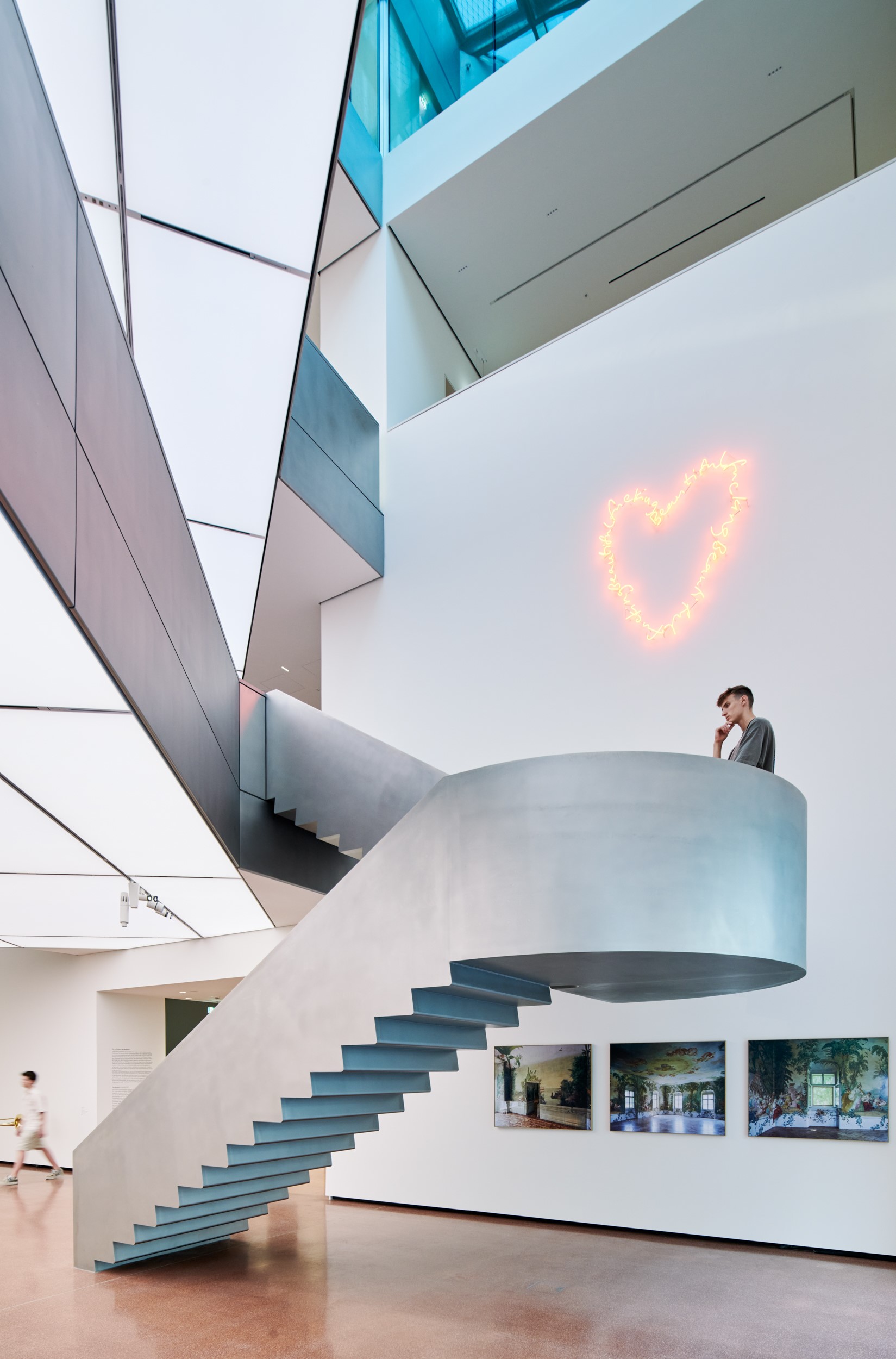 Skulptural ausgebildete Freitreppe aus glasperlgestrahltem Edelstahl verbindet zwei stützfreie Plateaus miteinander.